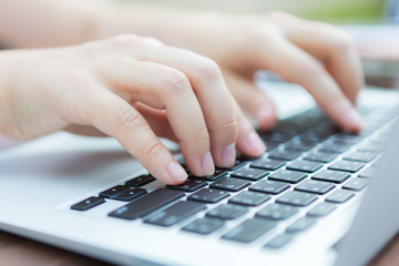 Closeup of business woman hand typing on laptop keyboard