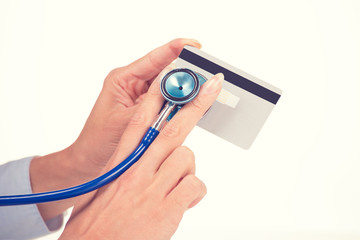 Woman hands holding listening credit card with stethoscope