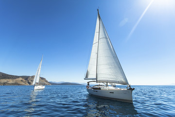 Yachts. Sailing in the wind through the waves at the Sea.