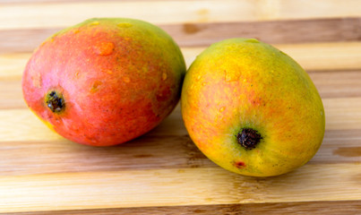 two mango on carving board
