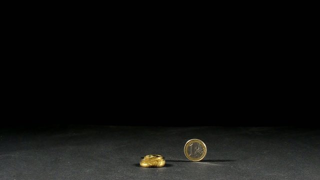 drei euro muenzen und eine in bewegung mit schwarzen hintergrund