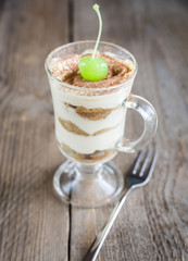 Tiramisu in the glass on the wooden background