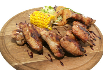 chicken wings are grilled on a wooden platter