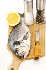 raw fish on a cutting board and knife
