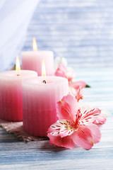 Plakat Beautiful candles with flowers on wooden background