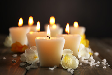 Obraz na płótnie Canvas Beautiful candles with flowers on wooden background