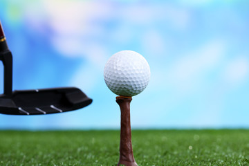 Golf ball and driver on green grass outdoor close up