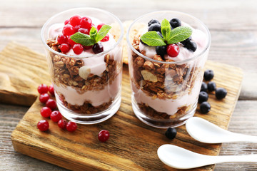 Healthy layered dessert with muesli and berries on table