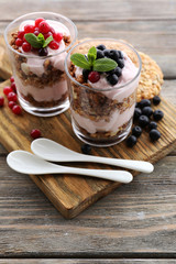 Healthy layered dessert with muesli and berries on table
