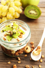 Healthy layered dessert with muesli and fruits on table