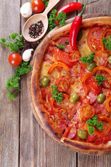 Tasty pizza with spices and spoon on wooden table background