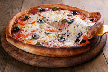 Pizza with cheese on board and wooden table background