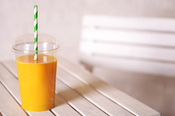 Orange juice in fast food closed cup with tube