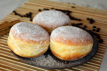 Donuts with powdered sugar on the brown plate