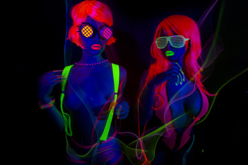 Fototapeta na wymiar two sexy neon uv glow dancers