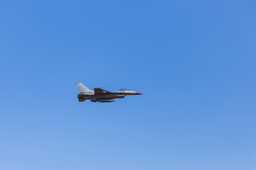 f16 falcon fighter jet flying on blue sky background