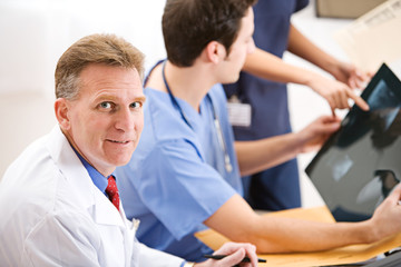 Obraz premium Doctors: Senior Doctor Helping with X-ray Results