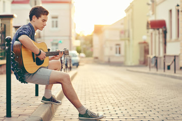 Handsome young man playing guitar