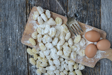 Gnocchi on Cutting Board and Rustic Wood Background