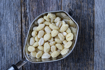Gnocchi in Strainer with Rustic Wood Background