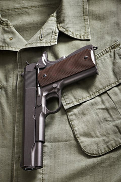 Colt pistol lie on military jacket