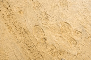 Fototapeta na wymiar Footprints on light sandy wet soil