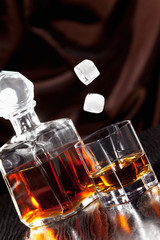 Eiswürfel fallen in ein Glas mit Whisky