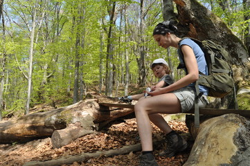 Resting on the trail. Mother and son in the mountains.