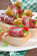 Snack on toast with ham, avocado and olives