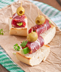 Snack on toast with ham, avocado and olives