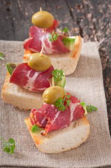 Snack on toast with ham, avocado and olives