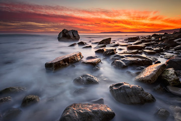 Obraz premium Rocky beach long exposure seascape at sunrise