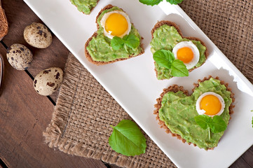 Sandwich with avocado paste and egg in the shape of heart