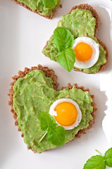 Sandwich with avocado paste and egg in the shape of heart
