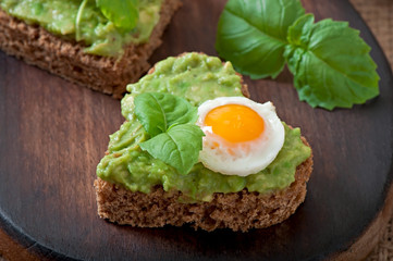 Sandwich with avocado paste and egg in the shape of heart