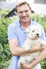 Portrait Of Man With Pet Dog In Garden