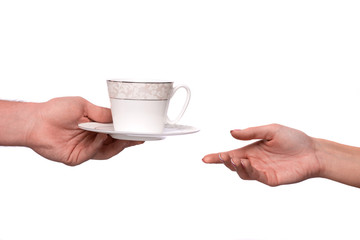 Hand giving cup and saucer