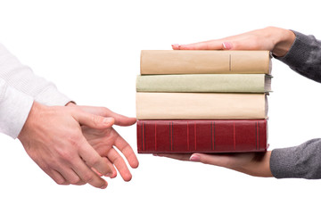 Hands passing heap of books