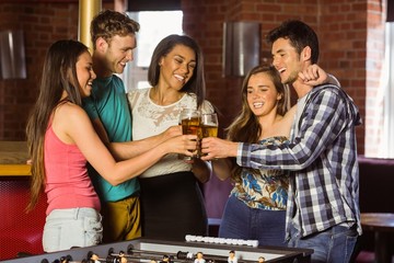 Portrait of happy friends toasting with mixed drink and beer