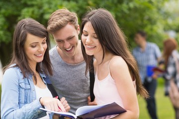 Happy students reading from notepad