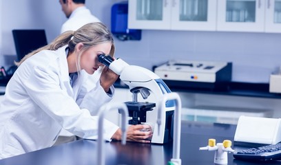 Science student looking through microscope in the lab