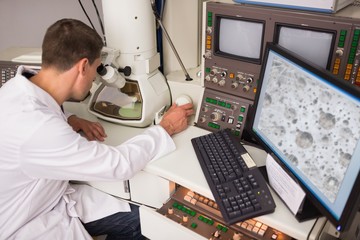 Biochemistry student using large microscope and computer