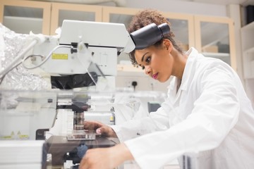 Pretty science student using microscope