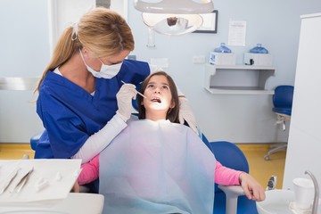 Pediatric dentist examining her young patient