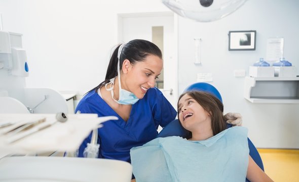 Cheerful pediatric dentist with a smiling young patient