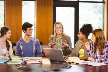 Smiling students and teacher in library