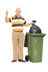 Senior giving a thumb up by a trash can