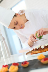 Pastry-cook shreding lemon zest over chocolate cake