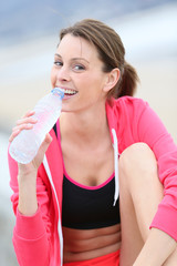 Jogger drinking water from bottle after exercising