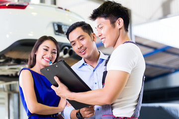 Car mechanic and Asian customer couple